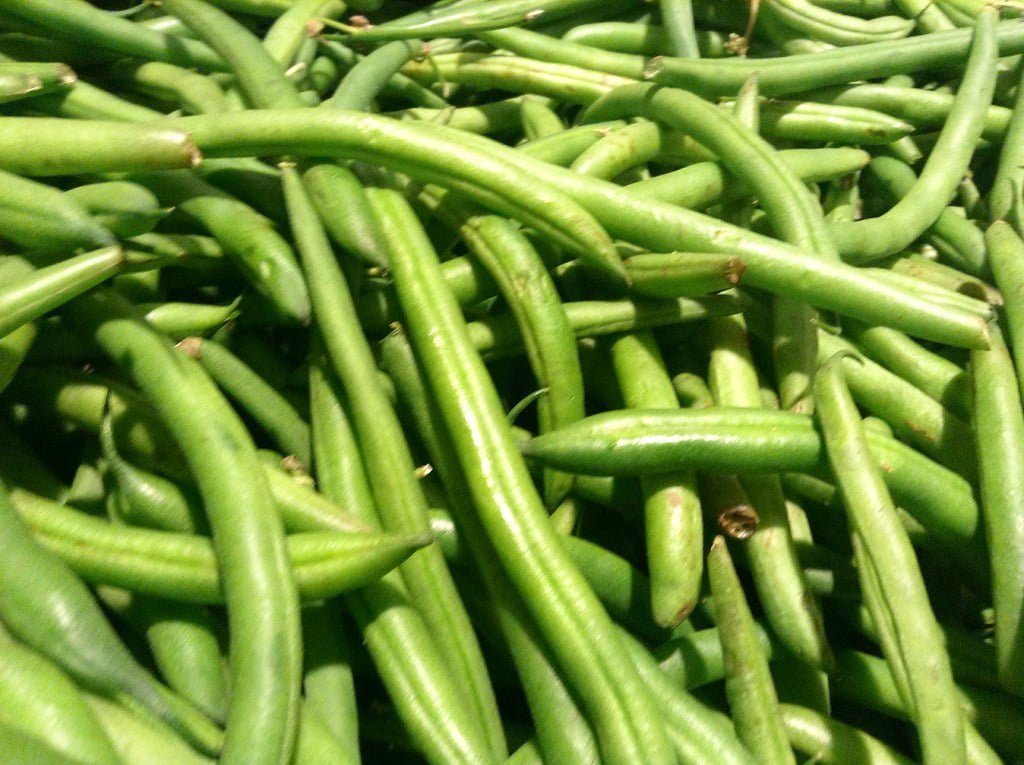A close-up image of a large pile of fresh green beans.